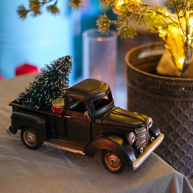 Svart plåtbil med julgran