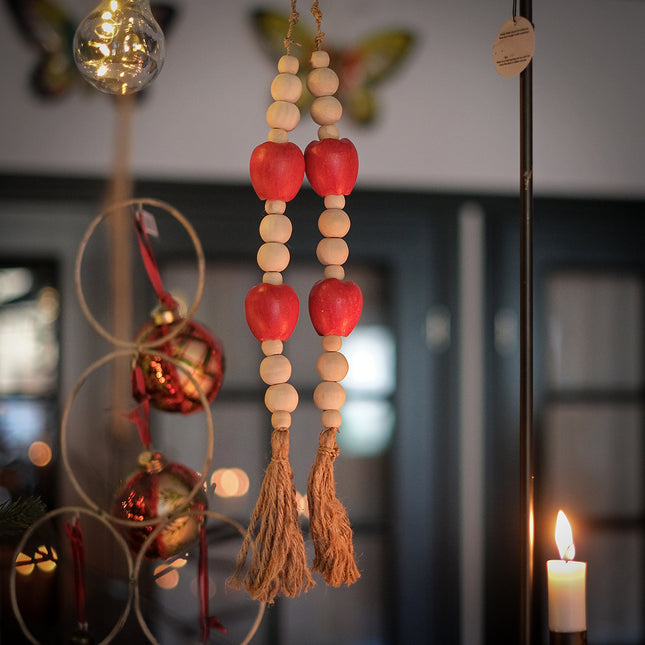 Hänge med träkulor och röda äpplen